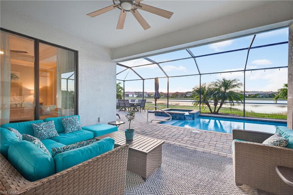 View of swimming pool featuring a sunroom, a patio, and glass enclosure