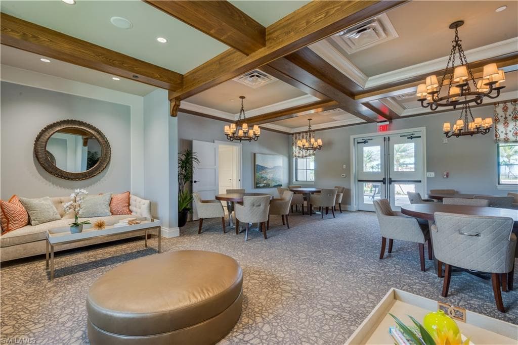 Living room featuring a chandelier, beam ceiling, french doors, and coffered ceiling