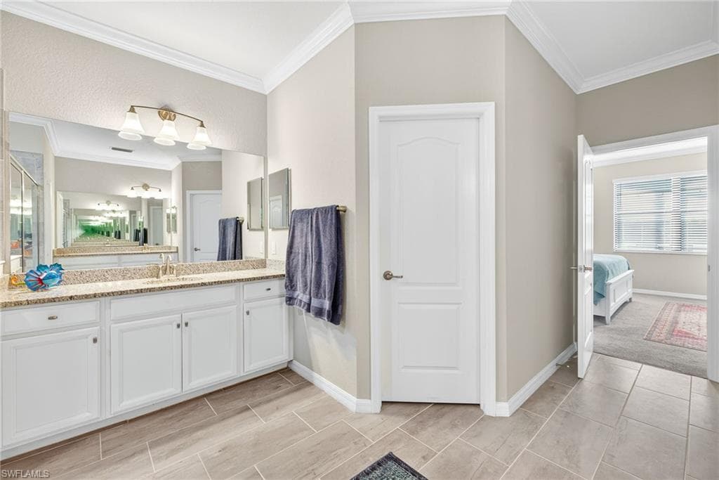 Ensuite bathroom with vanity and ornamental molding