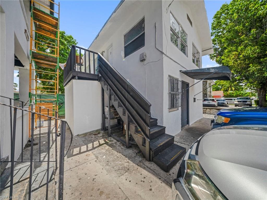 View of home's exterior with stucco siding and stairway