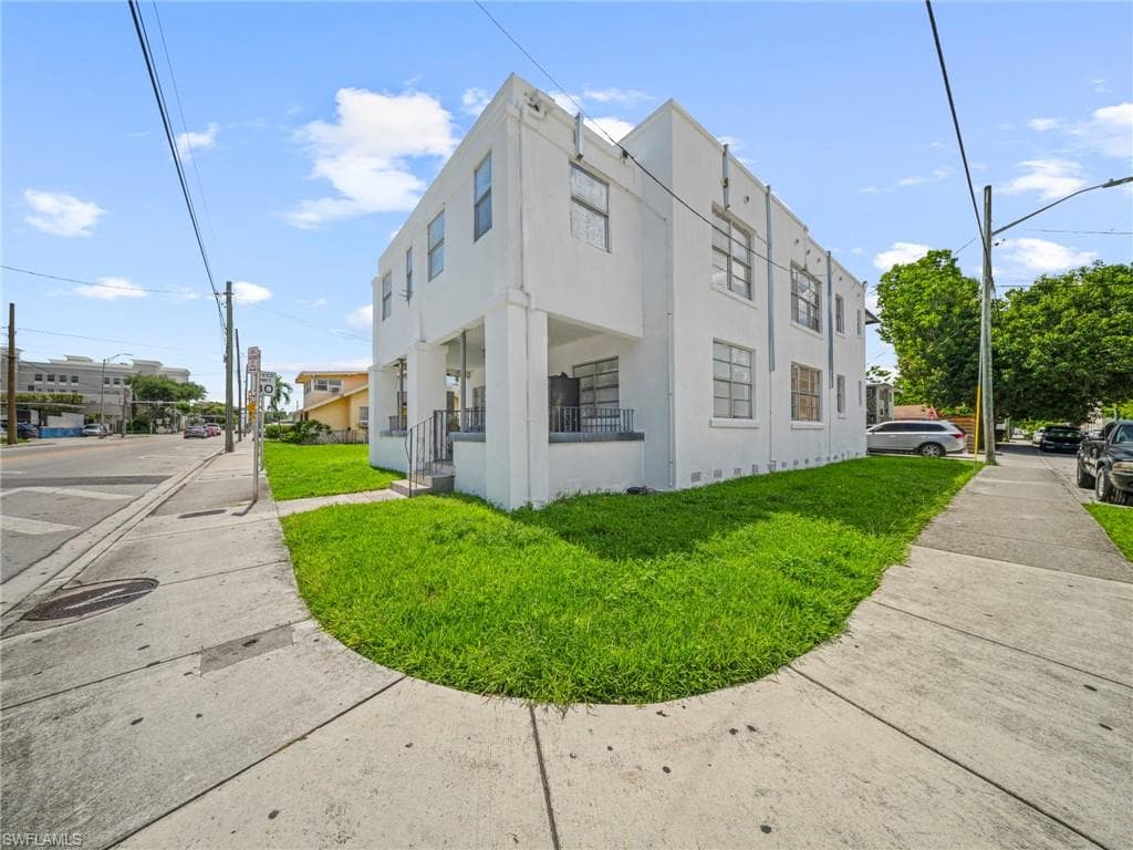 View of property exterior with a lawn and stucco siding