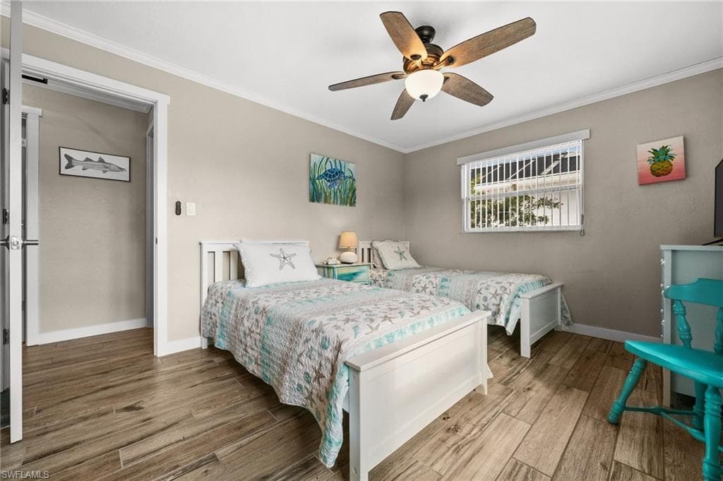 Bedroom featuring ornamental molding, ceiling fan, and wood finished floors