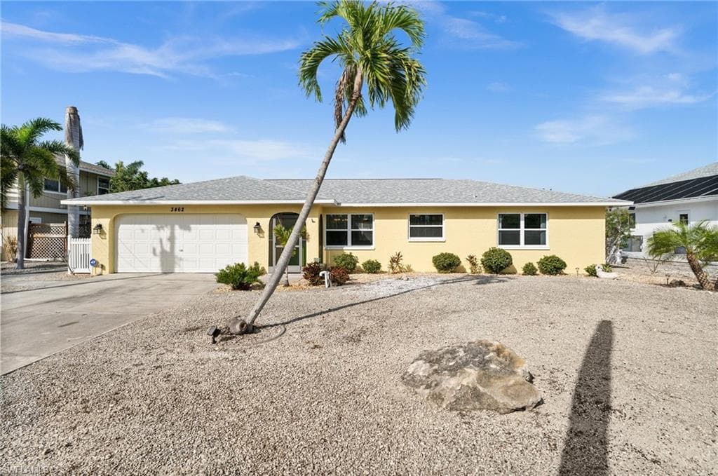 Ranch-style house featuring stucco siding, driveway, roof with shingles, and a garage