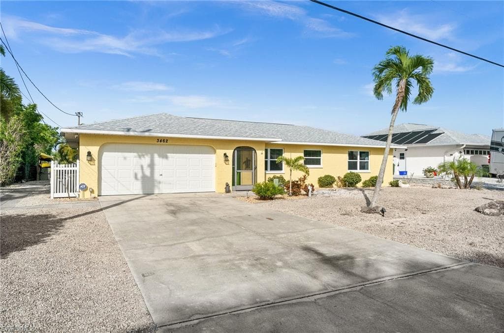 Single story home featuring stucco siding, driveway, an attached garage, and a shingled roof