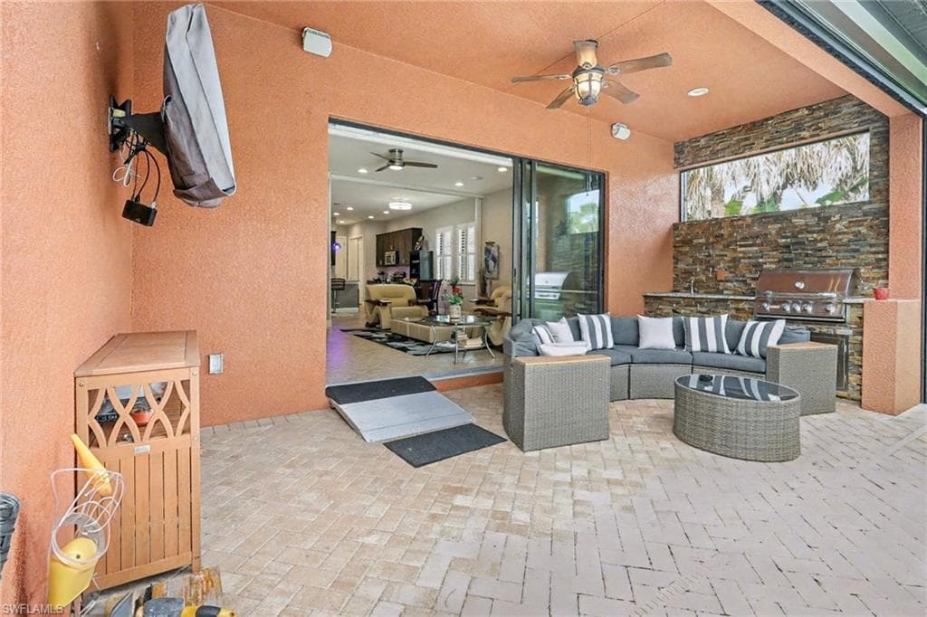 View of patio with ceiling fan, an outdoor living space, and an outdoor kitchen