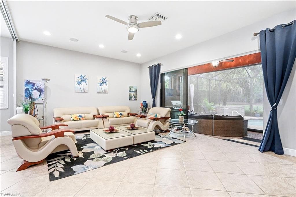 Living area with ceiling fan, light tile patterned floors, recessed lighting, and a sunroom