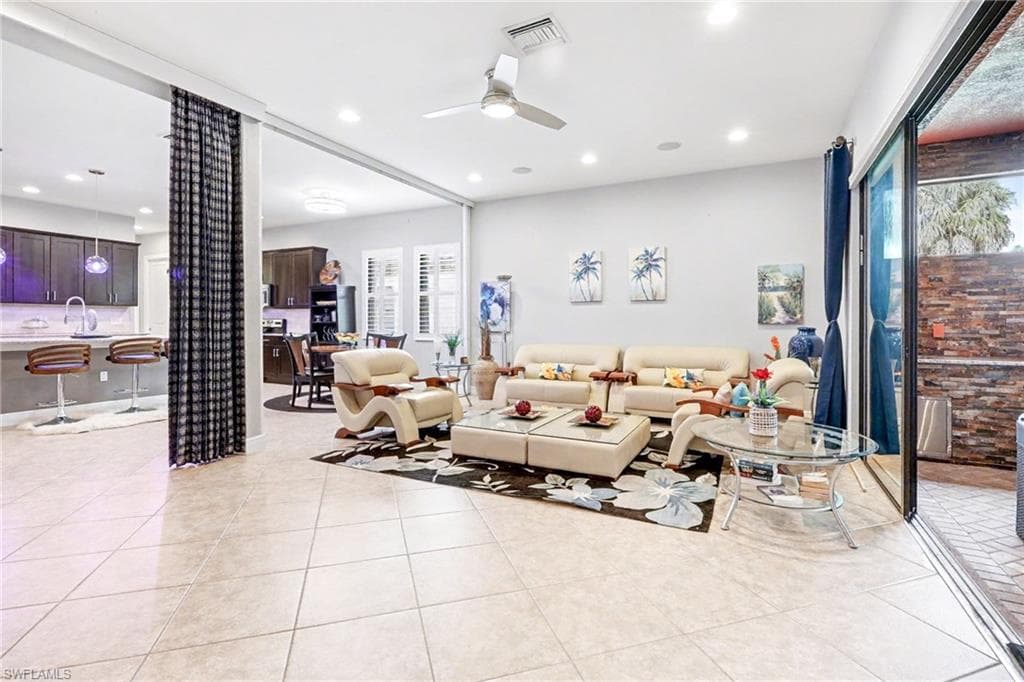 Living area with ceiling fan, light tile patterned floors, and recessed lighting