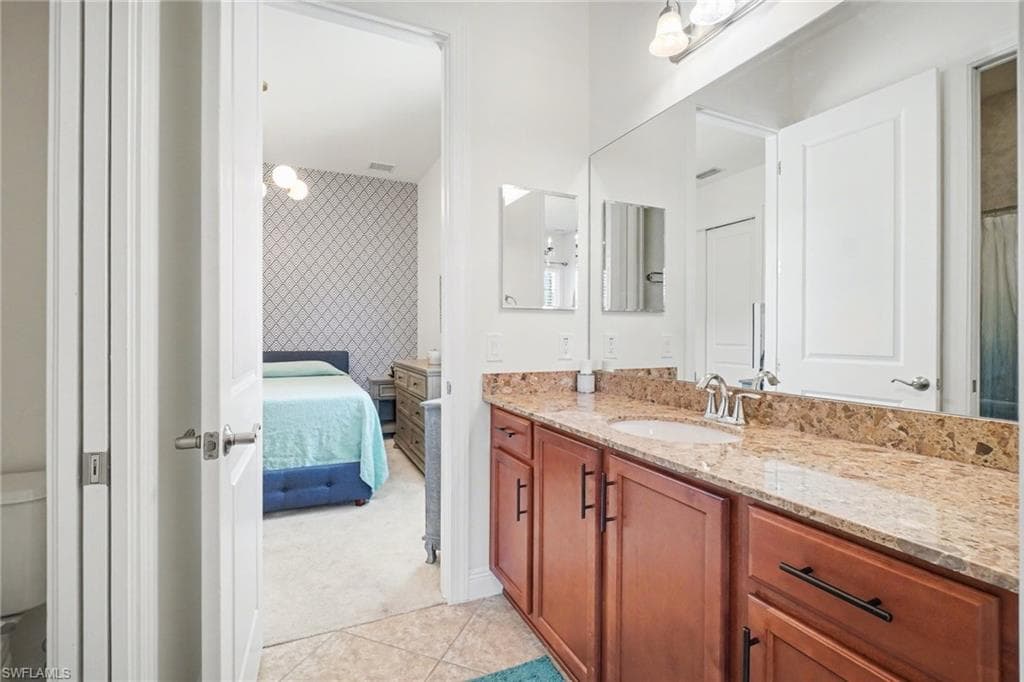 Bathroom with vanity, ensuite bath, light carpet, a shower with shower curtain, and an accent wall