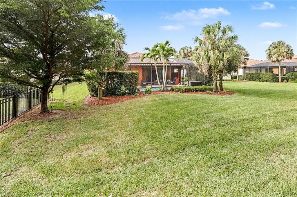 Back of property with a lanai, a sunroom, and an outdoor pool
