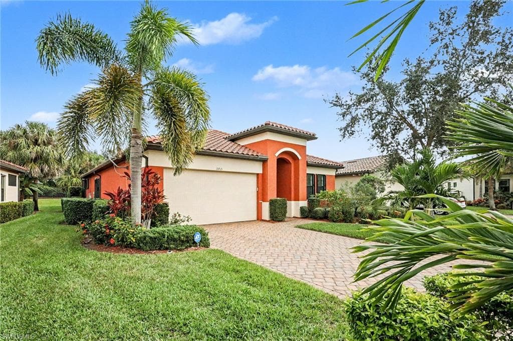Mediterranean / spanish-style home featuring a garage, stucco siding, decorative driveway, a front yard, and a tiled roof