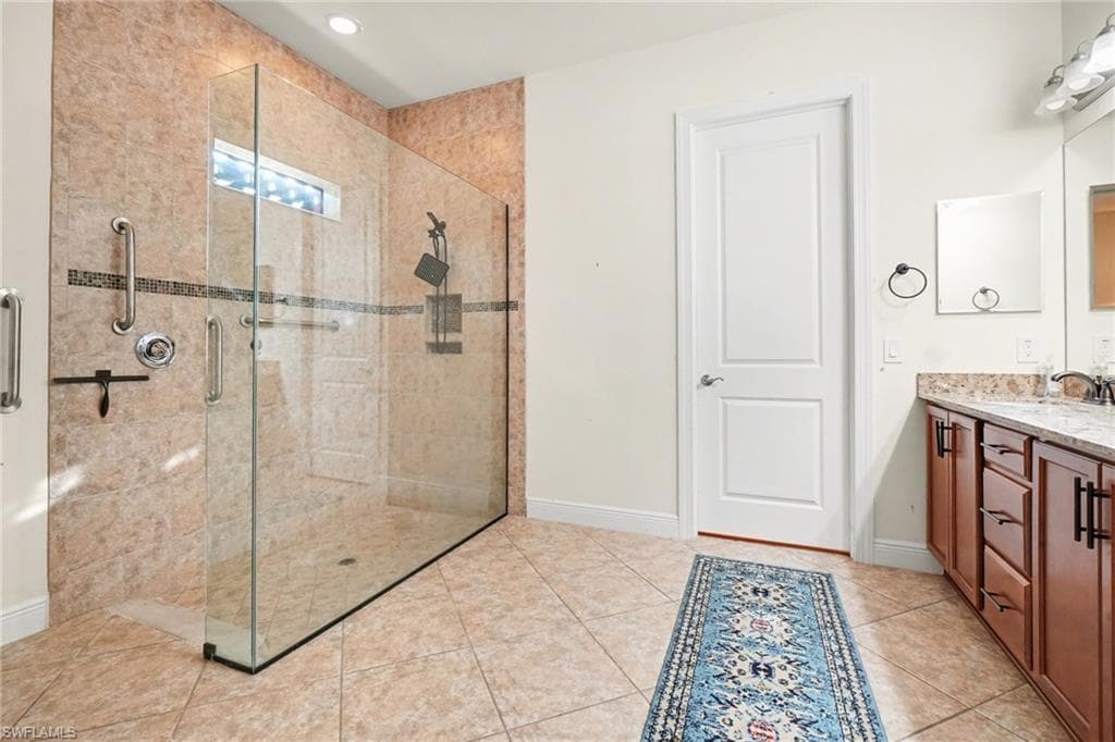 Bathroom featuring vanity, a stall shower, and light tile patterned flooring