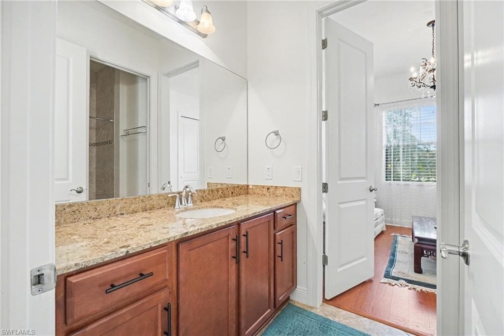 Bathroom featuring vanity, light wood finished floors, and a chandelier