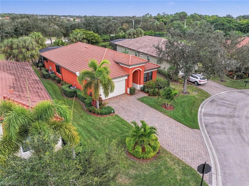 Aerial view of property and surrounding area featuring a tree filled landscape