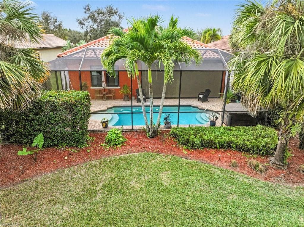 View of swimming pool with a lanai, a patio area, a sunroom, and a yard