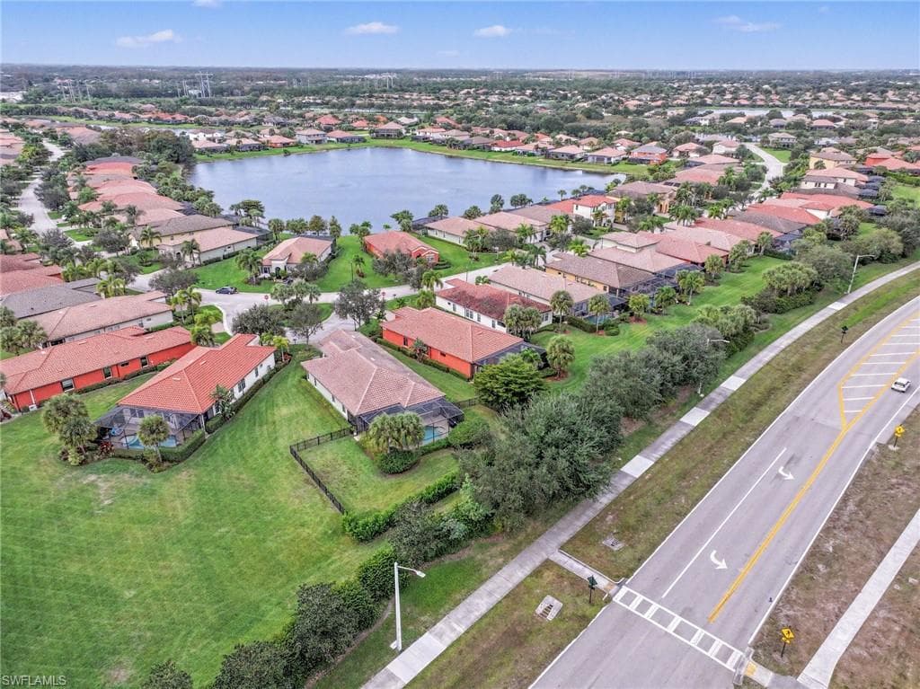 Aerial view of property and surrounding area featuring nearby suburban area