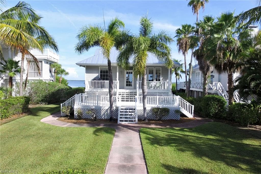 View of front of house featuring stairway, a front yard, and a metal roof