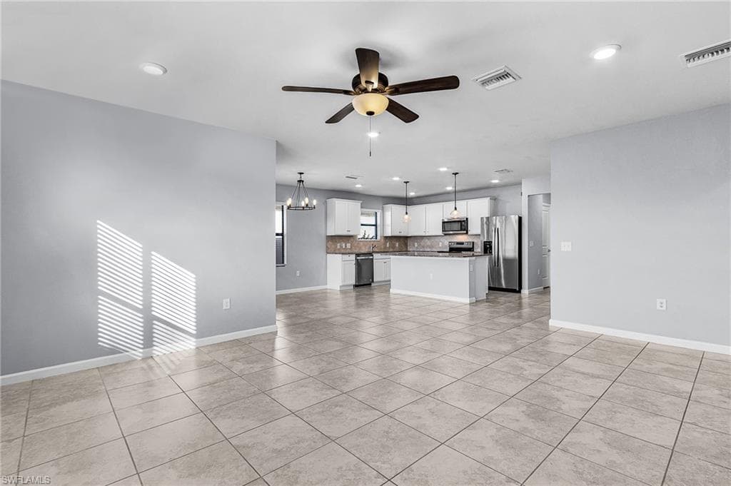 Living room featuring a chandelier, light tile patterned floors, ceiling fan, and recessed lighting