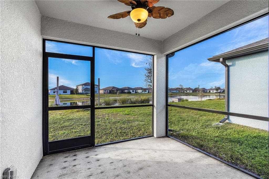 Large screened lanai featuring a ceiling fan, and serene water view