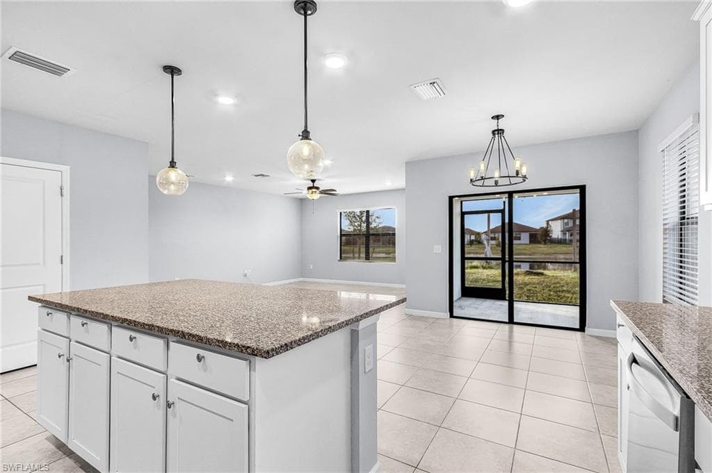 Kitchen featuring white cabinetry, light fixtures, granite countertops, a kitchen island, and recessed lighting