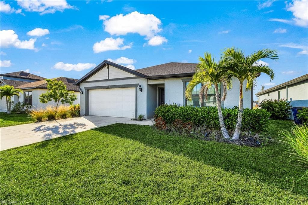 Single story home with concrete driveway, stucco siding, a front lawn, and a garage