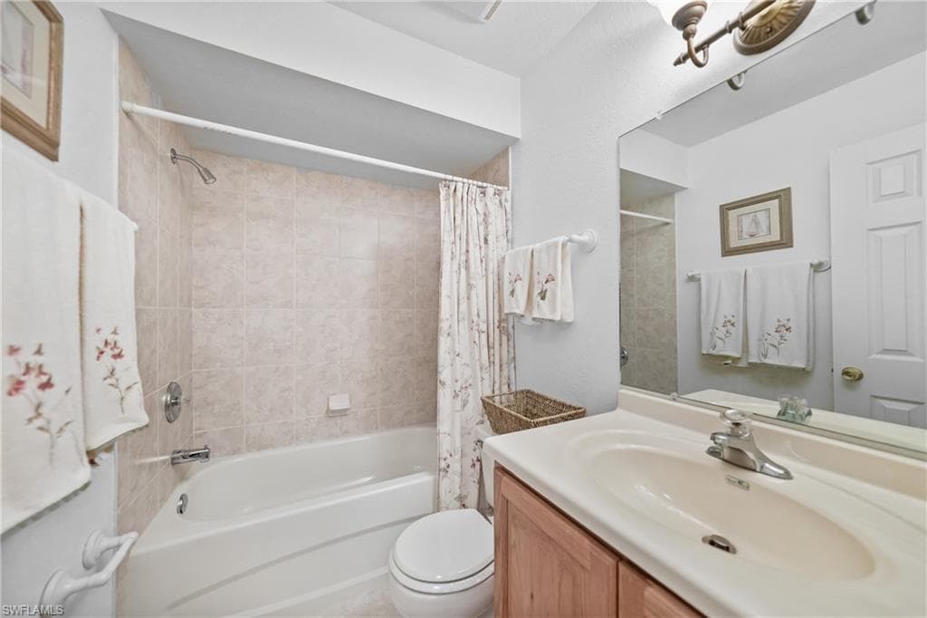 Bathroom featuring shower / bath combo with shower curtain and vanity