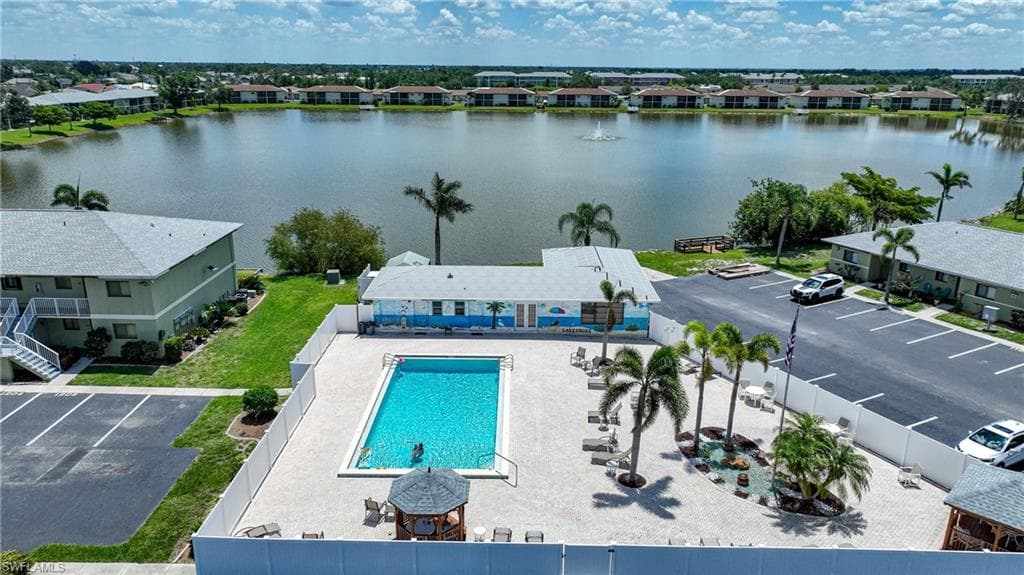 Drone / aerial view of a pool area and a nearby body of water