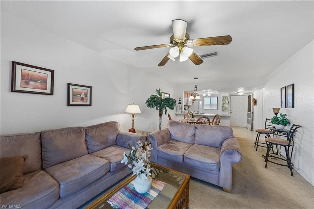 Living area with carpet flooring and ceiling fan