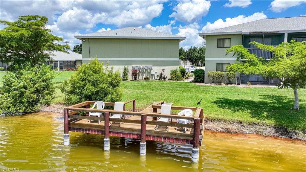 Dock area featuring a water view and a lawn