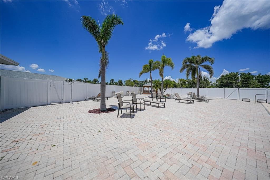 Fenced backyard featuring a gate and a patio area
