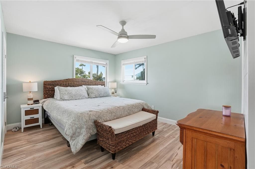 Bedroom featuring light wood-type flooring and a ceiling fan - Virtually Edited Image