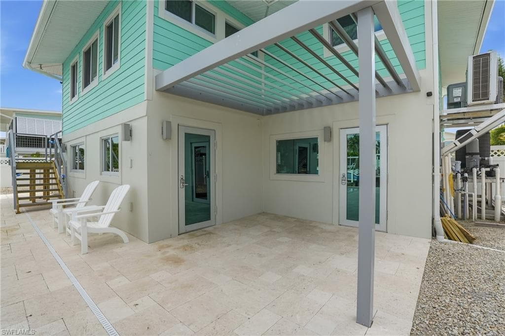 View of patio with a pergola and stairs - Virtually Edited Image