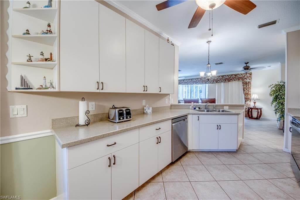 Kitchen featuring white cabinetry, open shelves, a peninsula, dishwasher, and decorative light fixtures