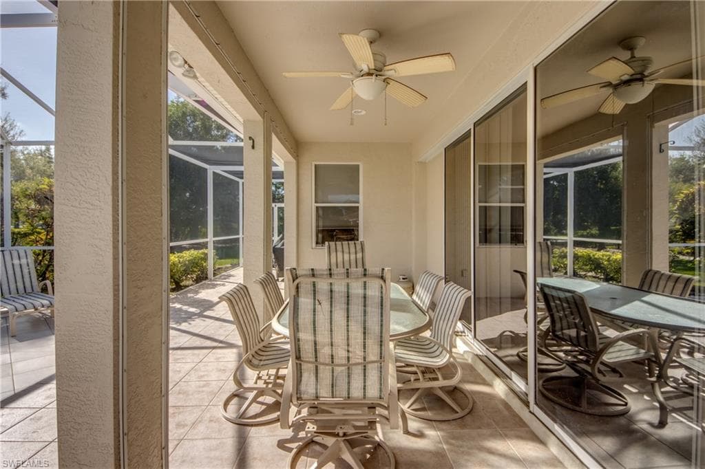 View of patio / terrace with outdoor dining area, ceiling fan, glass enclosure, and a sunroom