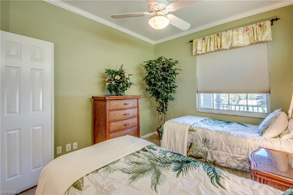 Bedroom with ceiling fan and crown molding