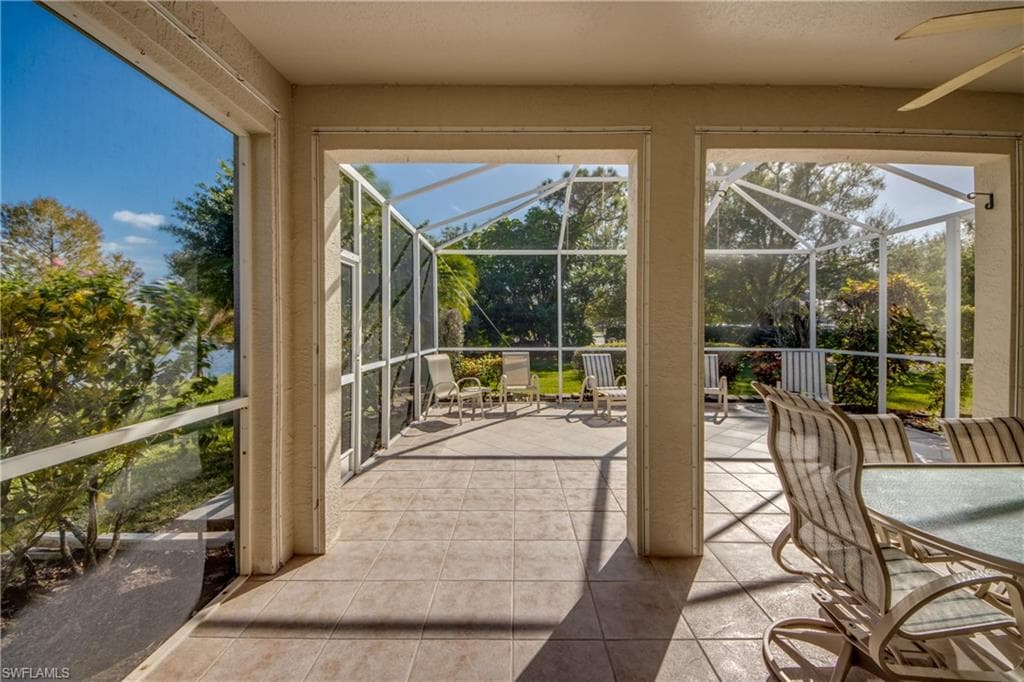 Unfurnished sunroom featuring a ceiling fan and a patio area