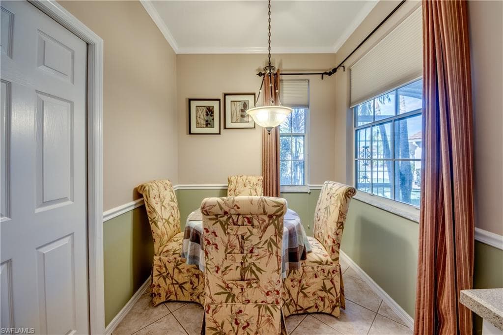 Dining room featuring ornamental molding and light tile patterned flooring
