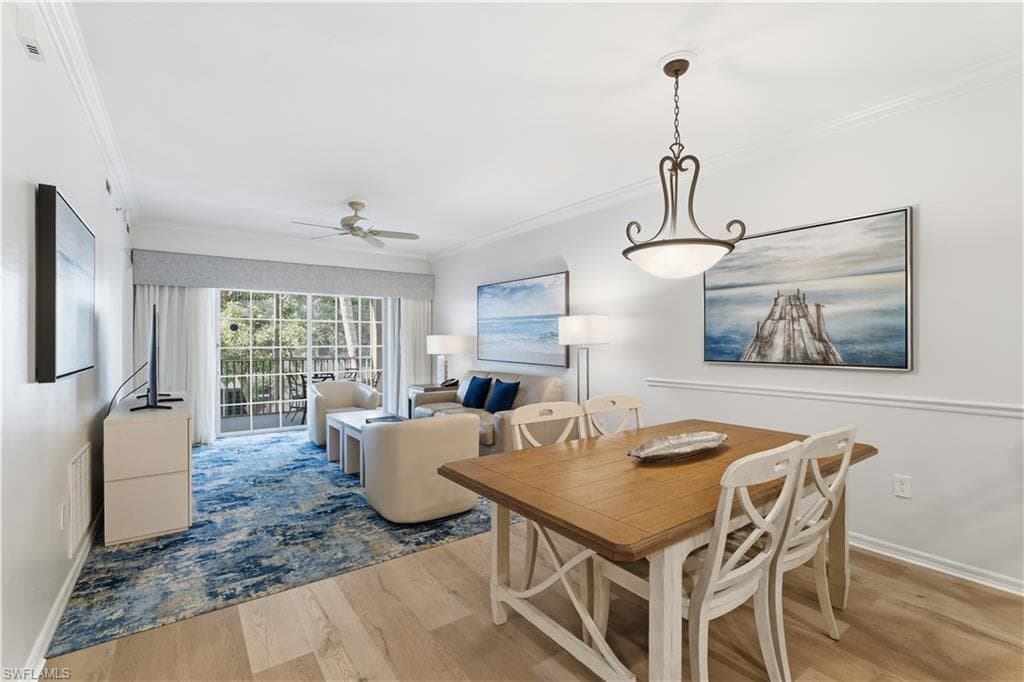 Dining space featuring ceiling fan, light wood-type flooring, and ornamental molding