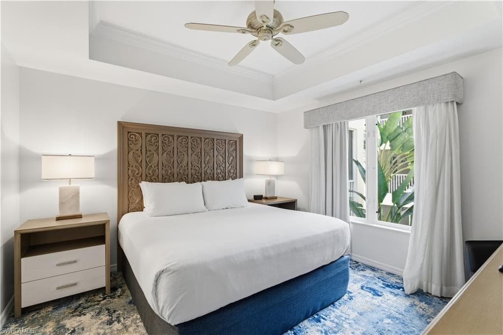 Bedroom featuring a tray ceiling, ornamental molding, and ceiling fan
