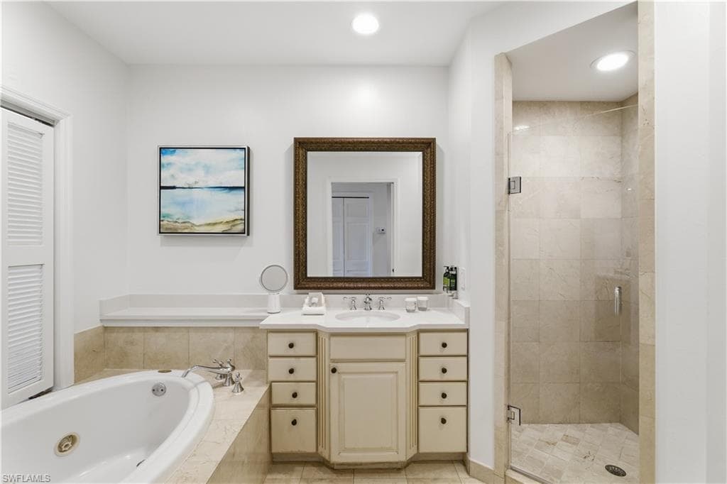 Bathroom with a shower stall, vanity, a whirlpool tub, light tile patterned flooring, and recessed lighting