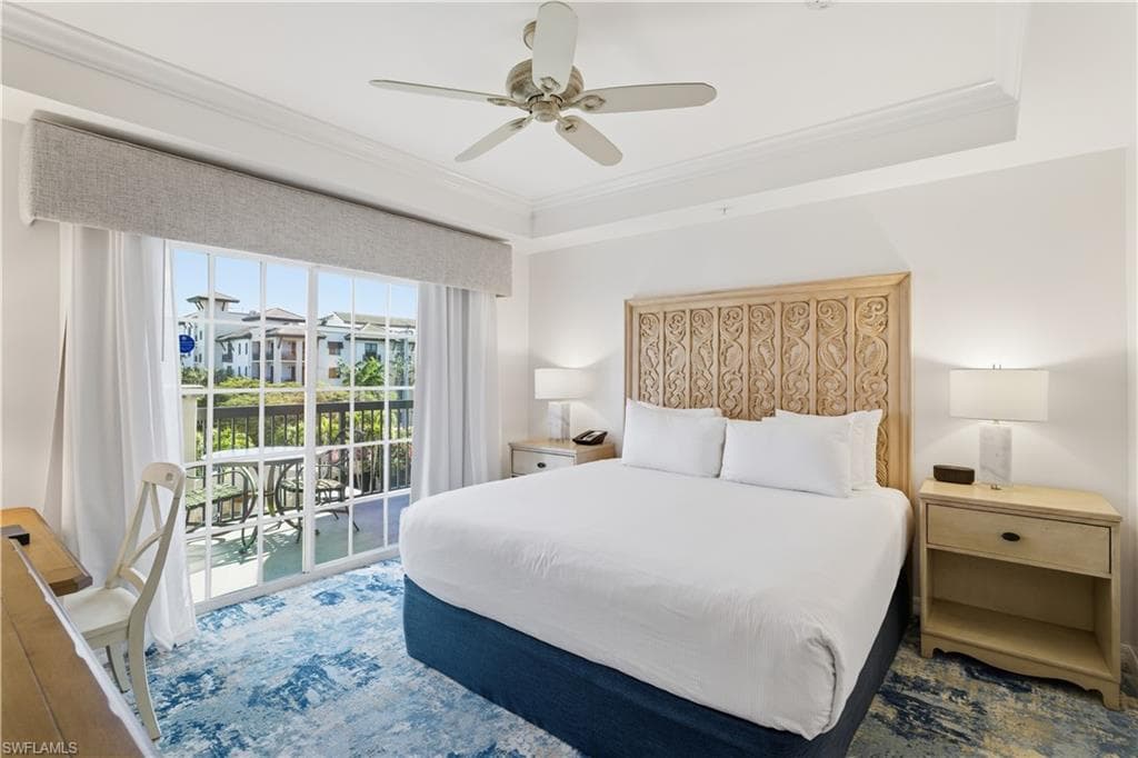 Bedroom with access to exterior, crown molding, a ceiling fan, and a tray ceiling