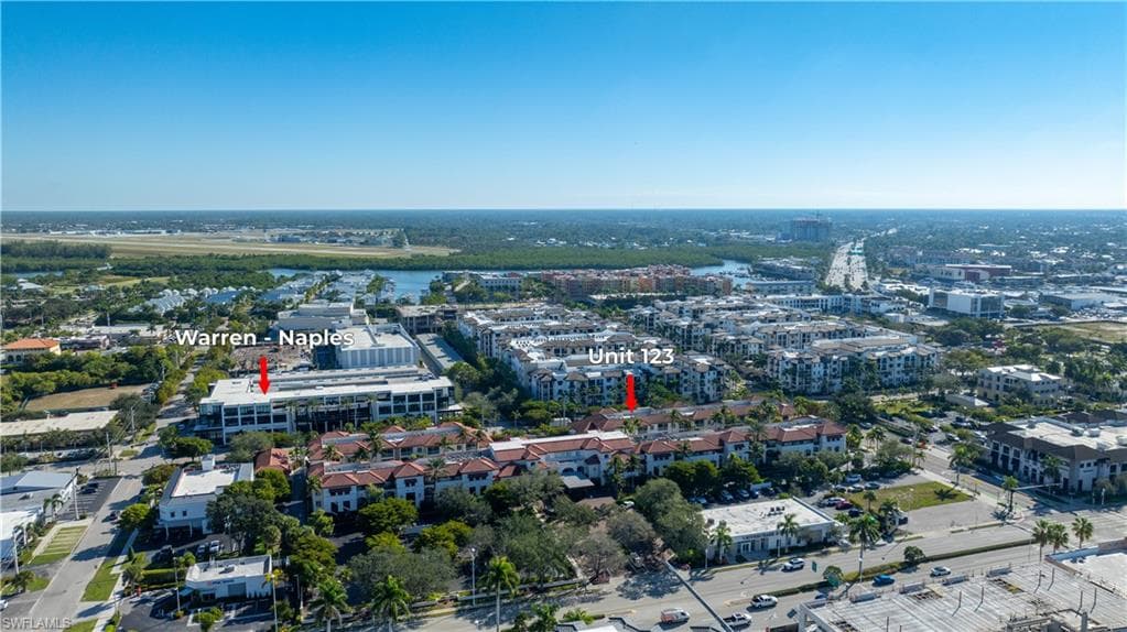 Aerial view of property and surrounding area featuring nearby urban area and a large body of water