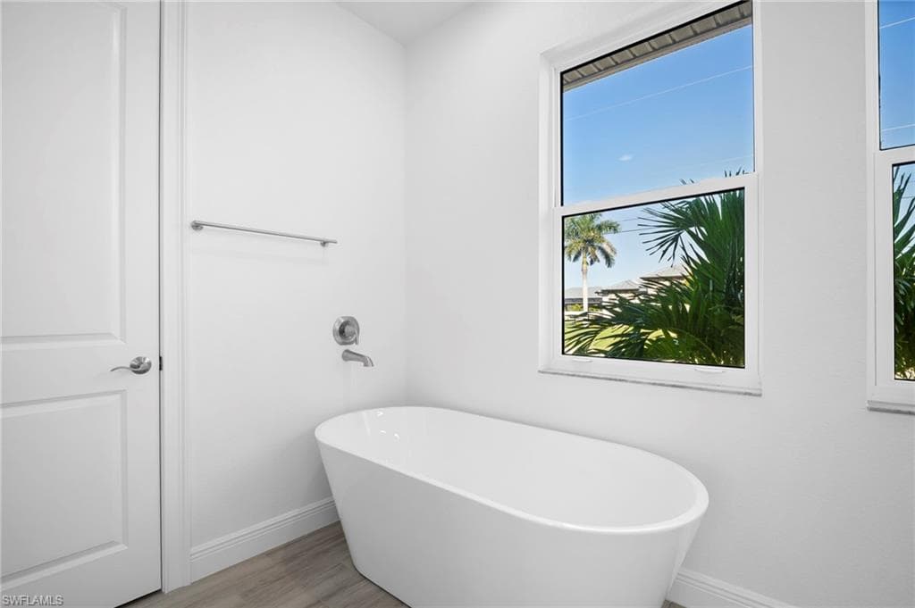 Bathroom featuring a soaking tub and light wood-style floors