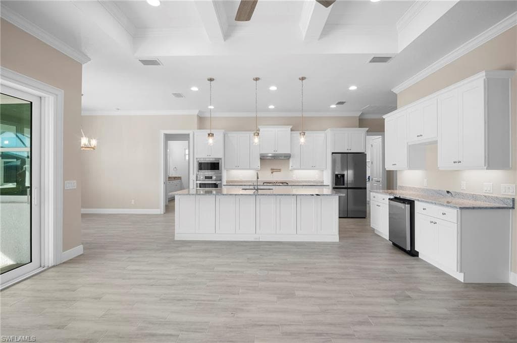 Kitchen with white cabinets, recessed lighting, hanging light fixtures, a chandelier, and appliances with stainless steel finishes