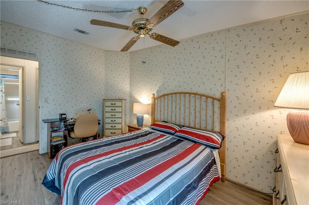 Bedroom featuring light wood finished floors, a textured ceiling, and ceiling fan
