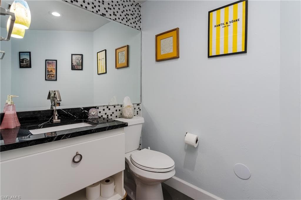 Half bathroom featuring vanity and baseboards