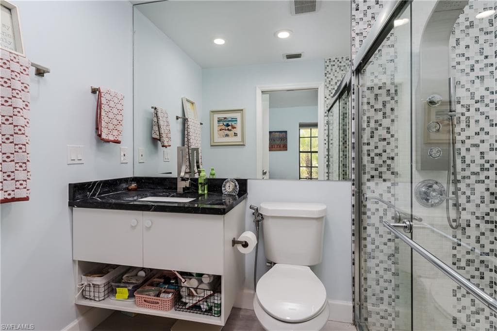 Full bathroom featuring vanity, a shower stall, and recessed lighting