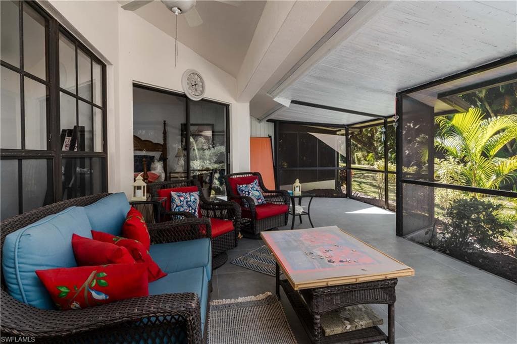 Sunroom featuring an outdoor hangout area, concrete flooring, lofted ceiling, and ceiling fan