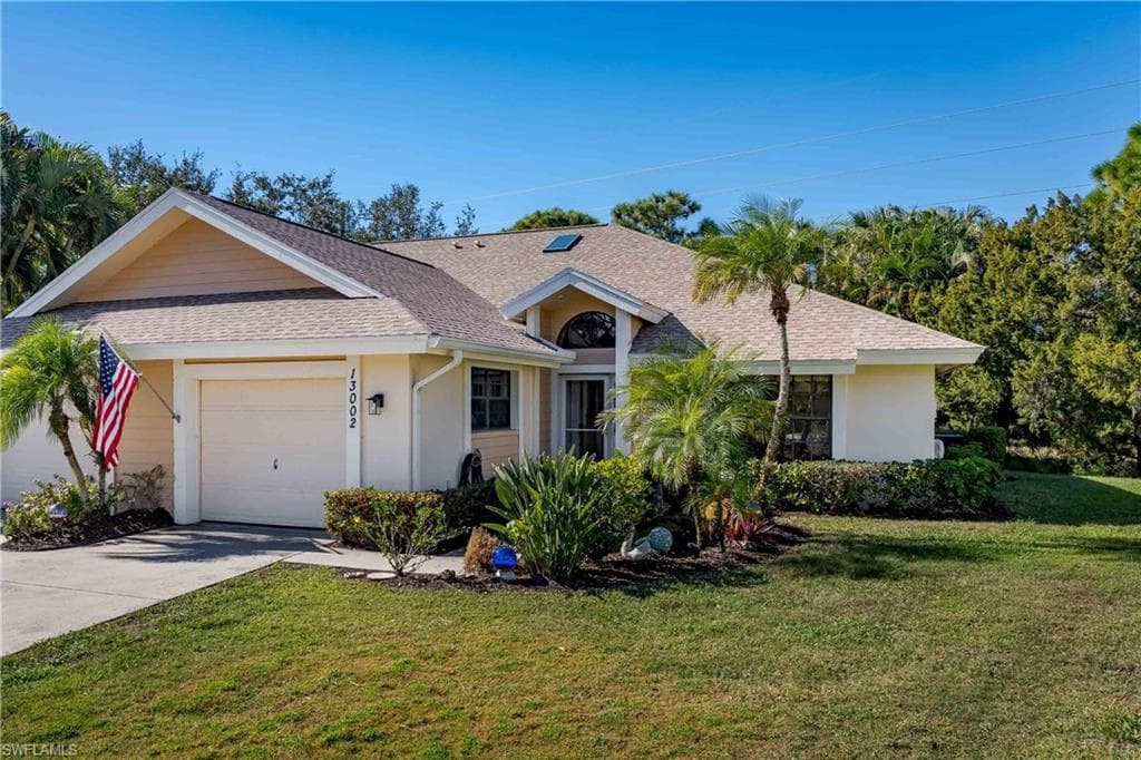 Single story home featuring roof with shingles, a front lawn, driveway, and a garage