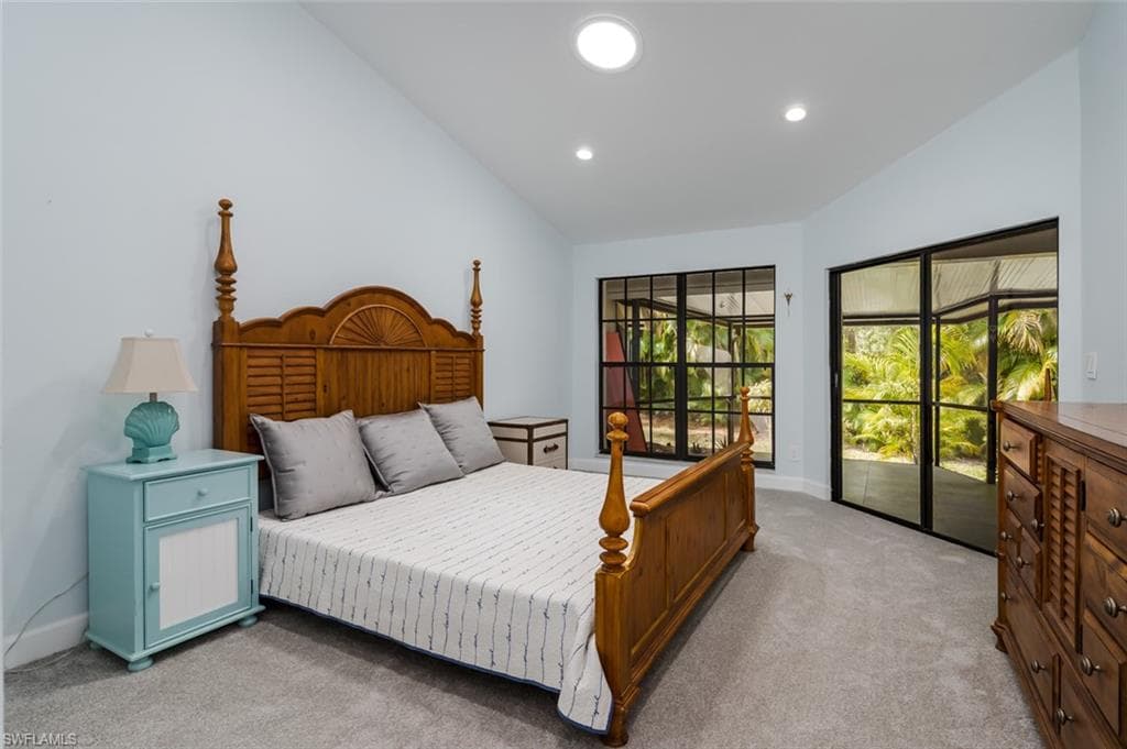 Bedroom with light carpet, lofted ceiling, and access to outside