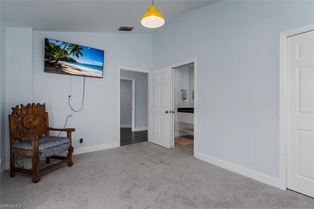 Living area featuring light colored carpet and lofted ceiling